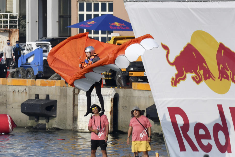 A team member jumps from a platform with a man made flying machine into the harbor in Taichung, a port city in central Taiwan on Sunday, Sept. 18, 2022. Pilots with homemade gliders launched themselves into a harbor from a 20-foot-high ramp to see who could go the farthest before falling into the waters. It was mostly if not all for fun as thousands of spectators laughed and cheered on 45 teams competing in the Red Bull “Flugtag” event held for the first time.(AP Photo/Szuying Lin)