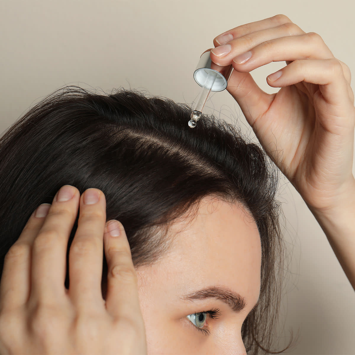 dark-haired-girl-applying-serum-scalp