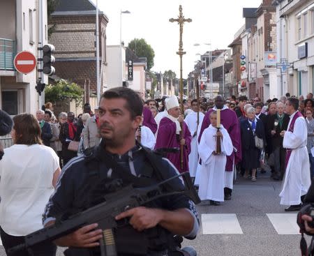 Archbishop of Rouen and Primate of Normandy Mgr Dominique Lebrun carries a Crucifix as he leads a procession, under security measures, to the memory of slain French priest, Father Jacques Hamel, in Saint-Etienne-du-Rouvray, France, October 2, 2016. REUTERS/Steve Bonet