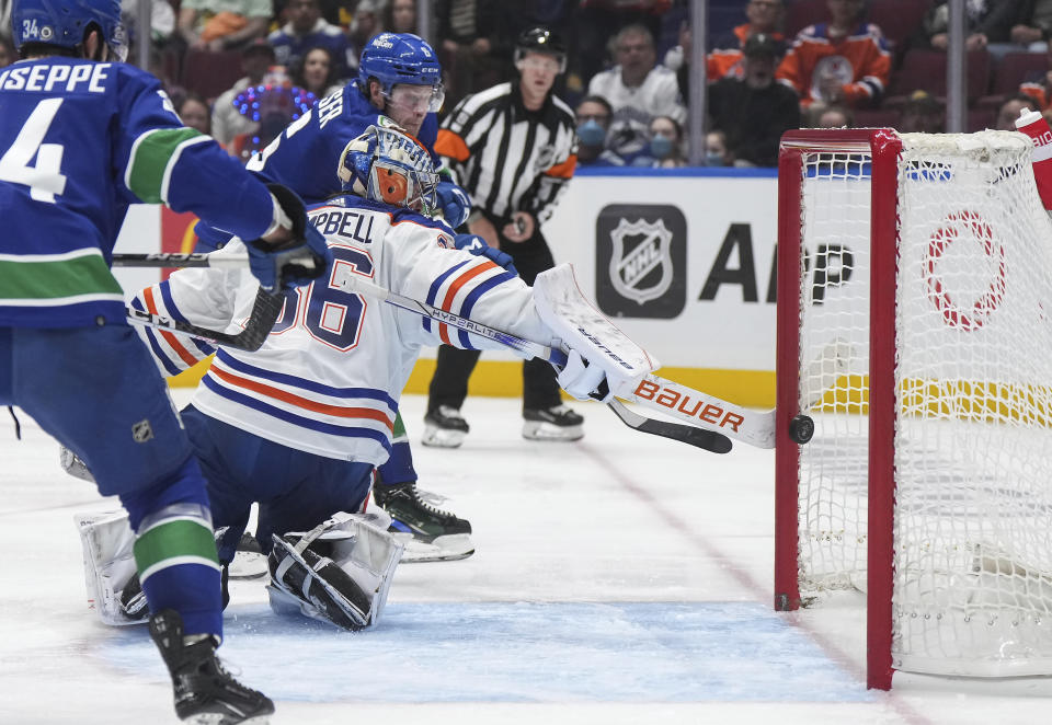 Vancouver Canucks' Brock Boeser, back, scores against Edmonton Oilers goalie Jack Campbell during the second period of an NHL hockey game Wednesday, Oct. 11, 2023, in Vancouver, British Columbia. (Darryl Dyck/The Canadian Press via AP)