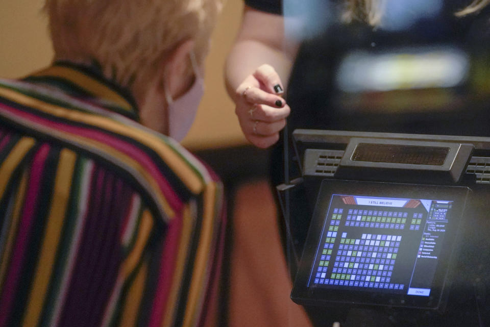 A patron looks over an image of the restricted seating chart as she considers buying a ticket for one of the first showings at the AMC theatre when it re-opened for the first time since shutting down at the start of the COVID-19 pandemic, Thursday, Aug. 20, 2020, in West Homestead, Pa. (AP Photo/Keith Srakocic)