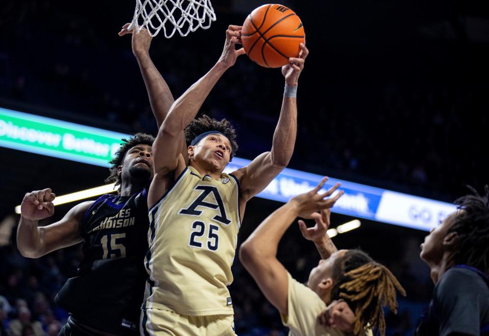 Akron forward Enrique Freeman (25) grabs a rebound against James Madison forward Jaylen Carey (15) during the first half of an NCAA college basketball game in Harrisonburg, Va., Saturday, Feb. 10, 2024. (Daniel Lin/Daily News-Record via AP)