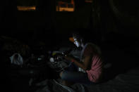 <p>A Central American migrant from El Salvador participating in the Migrant Stations of the Cross caravan is lit up by her cell phone during the caravan’s few-day’s stop at a sports center in Matias Romero, Oaxaca state, Mexico, late Monday, April 2, 2018. (Photo: Felix Marquez/AP) </p>