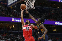 Washington Wizards guard Spencer Dinwiddie (26) goes to the basket against Indiana Pacers forward Justin Holiday, right, during the first half of an NBA basketball game Friday, Oct. 22, 2021, in Washington. (AP Photo/Nick Wass)