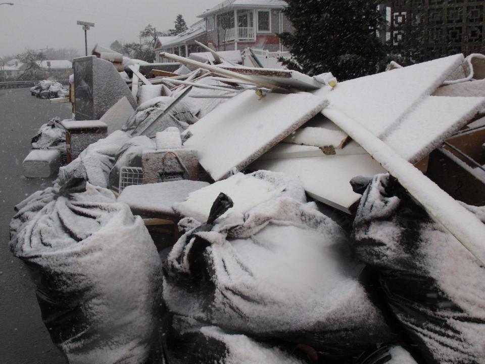 Snow covers debris piles as flood waters start to return to neighborhoods in Point Pleasant Beach, N.J., Wednesday Nov. 7, 2012, as a nor'easter hits. The storm was threatening new damage to areas of the Jersey shore already devastated last week by Superstorm Sandy. (AP Photo/Wayne Parry)