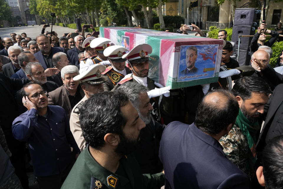 Army members carry the flag-draped coffin of Iranian Foreign Minister Hossein Amirabdollahian, who was killed in a helicopter crash along with President Ebrahim Raisi, during a funeral ceremony at the foreign ministry in Tehran, Iran, Thursday, May 23, 2024. The death of Raisi, Amirabdollahian and six others in the crash on Sunday comes at a politically sensitive moment for Iran, both at home and abroad. (AP Photo/Vahid Salemi)