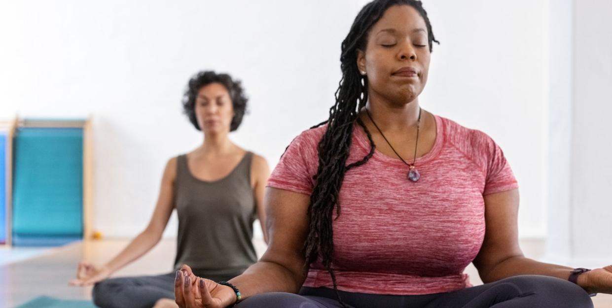 two women meditating on yoga mats