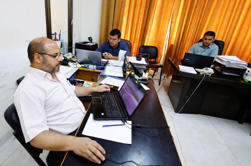 Palestinians employees work at Gaza government media office, in Gaza City