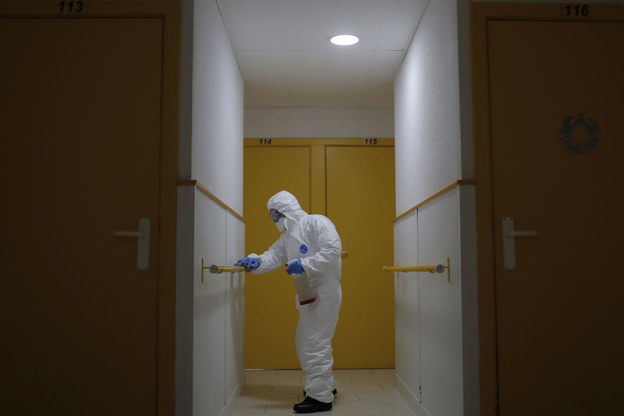 A member of the UME (Emergency Army Unit)  wearing a protective suit to protect against coronavirus disinfects handrails at a nursing home in Madrid, Spain, on Tuesday, March 31, 2020.