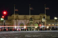 Birdwatchers line Columbus Circle in front of Union Station in Washington, Friday, Jan. 7, 2022, hoping for a glimpse of a rare snowy owl that has been seen there and around Washington's Capitol Hill neighborhood. (AP Photo/Carolyn Kaster)