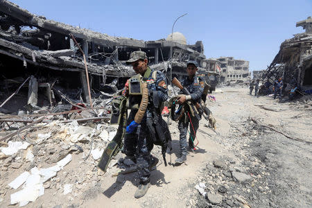 Members of Iraqi Federal police carry suicide belts used by Islamic State militants in the Old City of Mosul, Iraq July 9, 2017. REUTERS/Alaa Al-Marjani