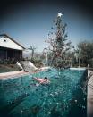 <p>The wife of Hollywood photographer Slim Aarons floats beneath a Christmas tree in their pool. Um, seriously, how amazing?</p>