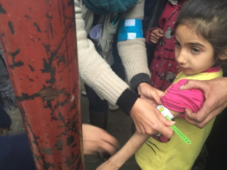 A UNICEF employee measures the arm of a malnourished child in the besieged Syrian town of Madaya, as they assess the health situation of residents in January 2016