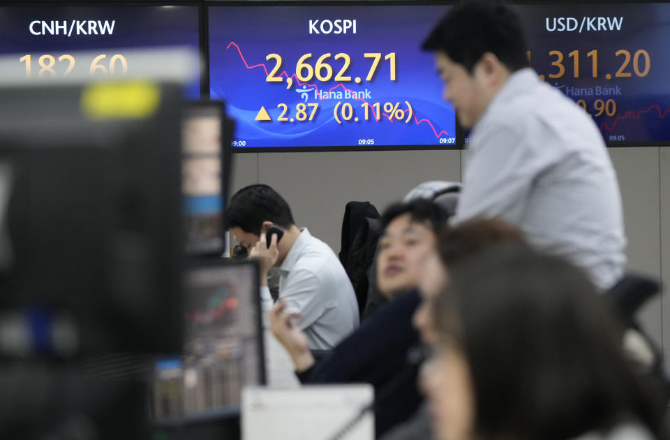 Currency traders work near the screens showing the Korea Composite Stock Price Index (KOSPI), center, and the foreign exchange rate between U.S. dollar and South Korean won, right, at the foreign exchange dealing room of the KEB Hana Bank headquarters in Seoul, South Korea, Tuesday, March 12, 2024. Shares were mostly higher in Asia on Tuesday ahead of a report on inflation in the U.S. that could sway the Federal Reserve’s timing on cutting interest rates. (AP Photo/Ahn Young-joon)