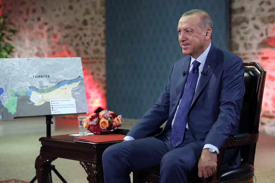 In this photo taken late Thursday, Oct. 24, 2019, Turkish President Recep Tayyip Erdogan speaks during an interview with Turkey's state television, TRT, in Istanbul. Erdogan told the TRT that the United States should hand the Syrian Democratic Forces' commander Mazloum Abdi over to Turkey, calling him a "terrorist" wanted in Turkey. (Presidential Press Service via AP, Pool )