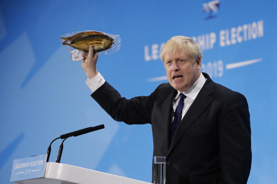 British Prime Minister Boris Johnson holds up a smoked kipper in plastic packaging.&nbsp; (Photo: TOLGA AKMEN via Getty Images)