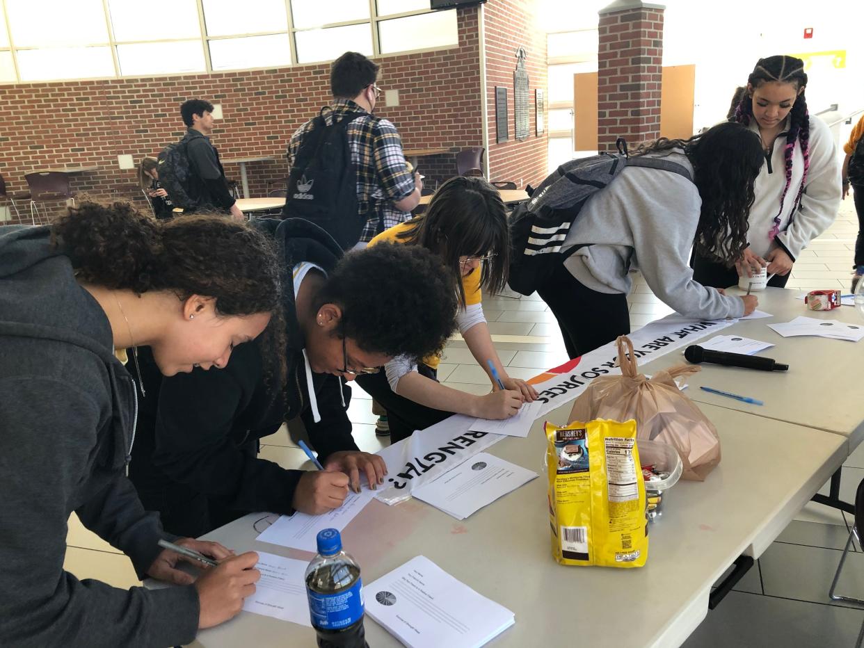 Newark High School students fill out sheets to enter raffles for River Road Coffee House gift cards during Wednesday's lunch hour in the Commons. As part of the Sources of Strength project, they had to explain  "why your friend is a positive friend" on their entries.