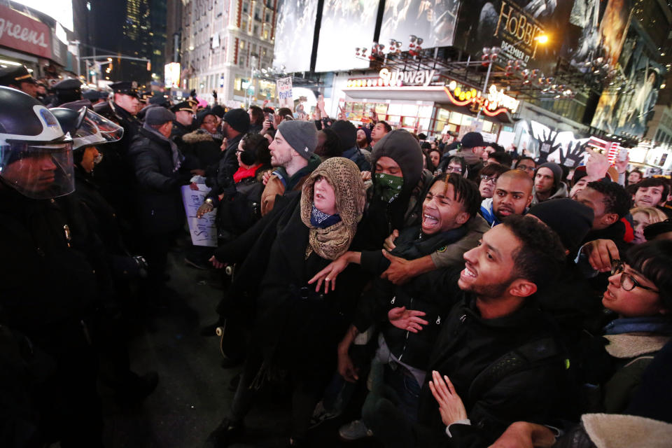 Protesters rallying against a grand jury's decision not to indict the police officer involved in the death of Eric Garner confront police as they attempt to block traffic at the intersection of 42nd Street and Seventh Avenue near Times Square, Thursday, Dec. 4, 2014, in New York. (AP Photo/Jason DeCrow)