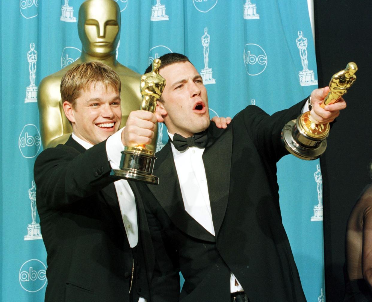 LOS ÁNGELES, CA - 23 DE MARZO: Los ganadores del Oscar Matt Damon (izq.) y Ben Affleck sostienen los premios que  al Mejor Guion Original por la película 
