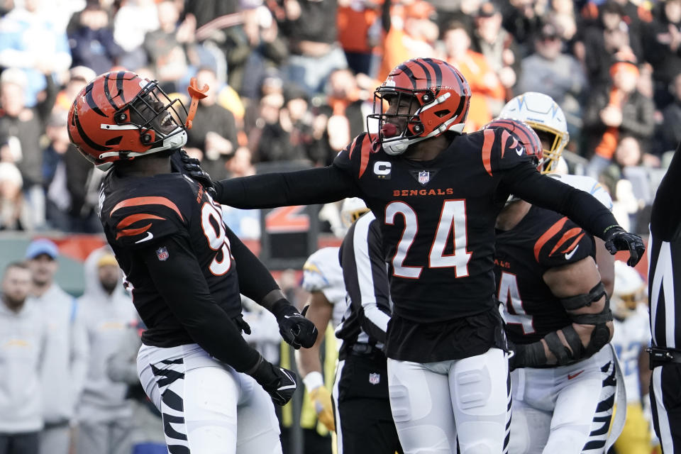 Cincinnati Bengals' Cameron Sample (96) and Vonn Bell (24) celebrate a sack of Los Angeles Chargers' Justin Herbert during the second half of an NFL football game, Sunday, Dec. 5, 2021, in Cincinnati. (AP Photo/Jeff Dean)