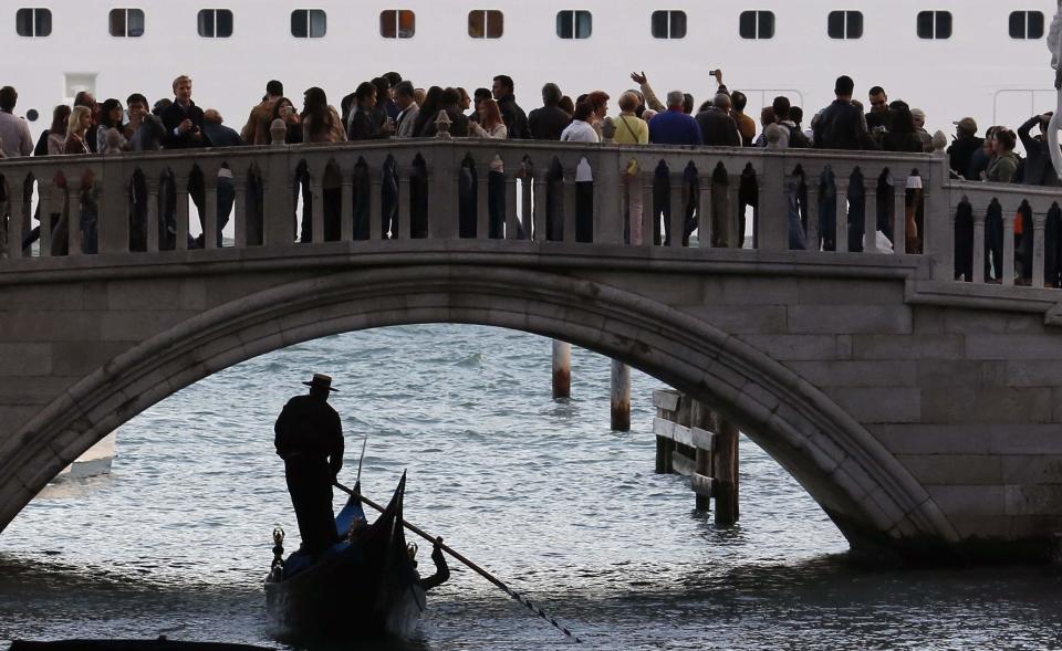 A gondolier rows in a canal near St. Mark's Square in Venice