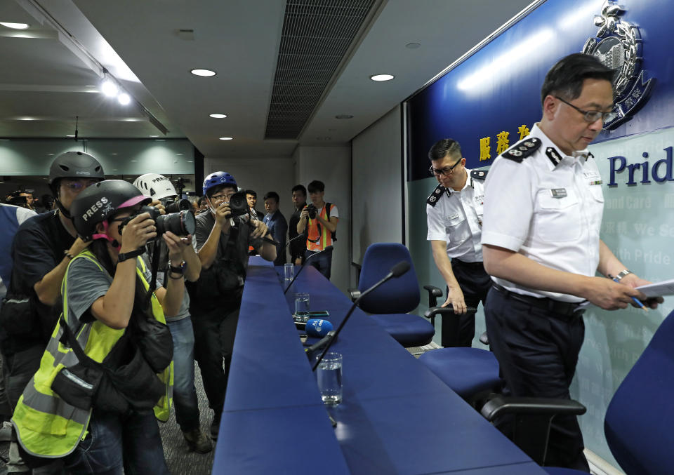 Press photographers wearing helmets for protection in the clashes seen in recent protests, photograph a press conference by Commissioner of Police Stephen Lo in Hong Kong, Thursday, June 13, 2019. (AP Photo/Vincent Yu)