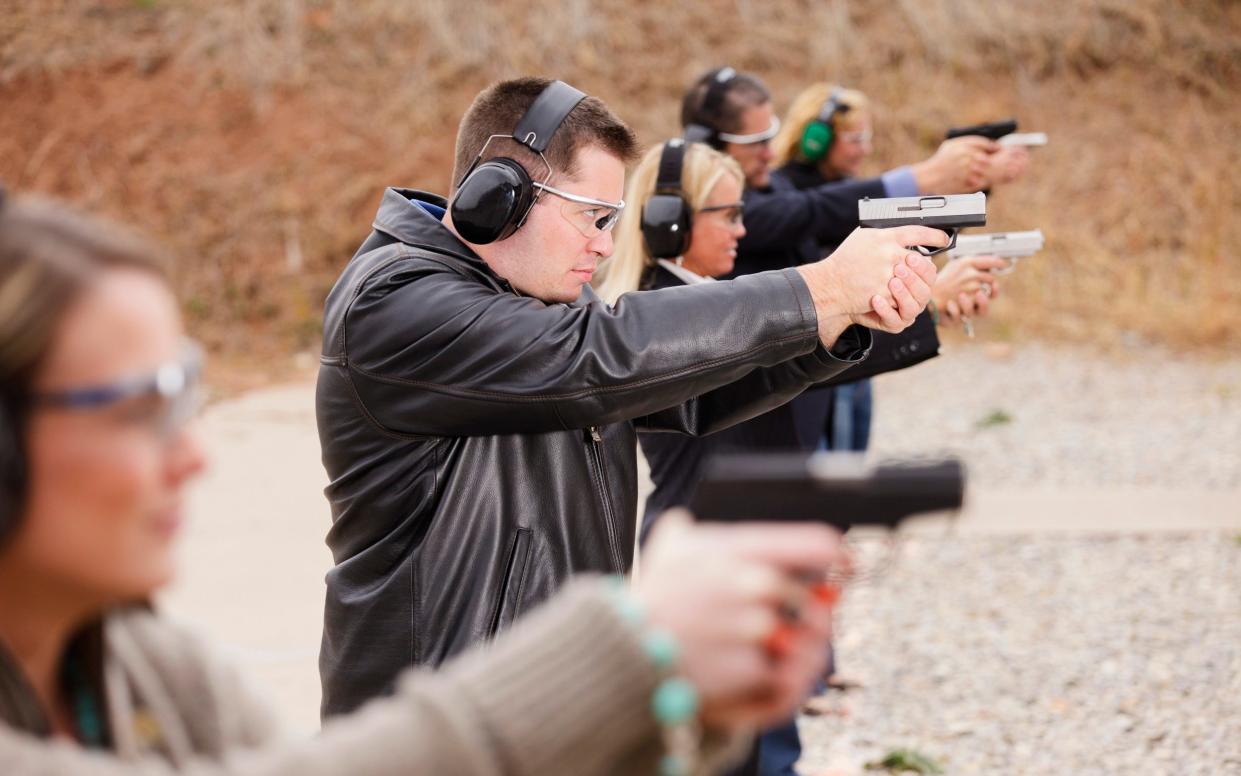 A group of people practicing at the gun range. Photographed on location at a shooting range.