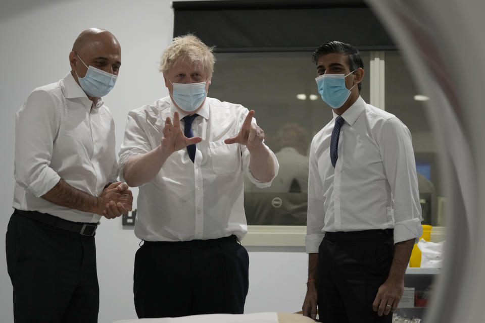Britain's Prime Minister Boris Johnson, centre, Rishi Sunak, Chancellor of the Exchequer, right, and Sajid Javid, Secretary of State for Health and Social Care speak together as they look at a CT scanner during a visit to the New Queen Elizabeth II Hospital, Welwyn Garden City, England, Wednesday, April 6, 2022. (AP Photo/Frank Augstein, Pool)