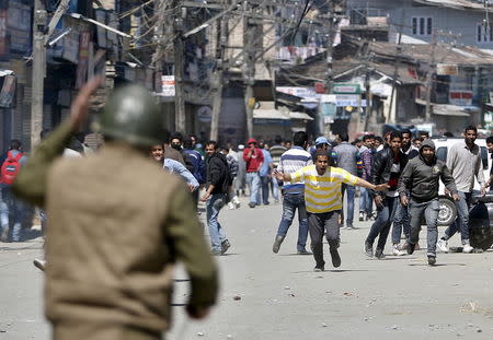 Kashmiri protesters run towards Indian security personnel during a demonstration against the plan to resettle Hindus, in Srinagar April 10, 2015. REUTERS/Danish Ismail