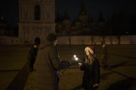 A girl lights a sparkler in Sophia Square before curfew on New Year's Eve in Kyiv, Ukraine, Saturday, Dec. 31, 2022. Multiple blasts rocked the capital and other areas of Ukraine on Saturday. (AP Photo/Felipe Dana)