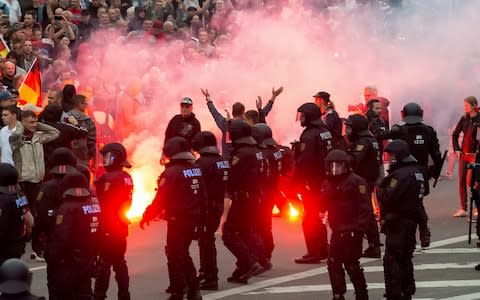  In this Aug. 27, 2018 photo protesters light fireworks during a far-right demonstration in Chemnitz, Germany. - Credit: Jens Meyer/AP