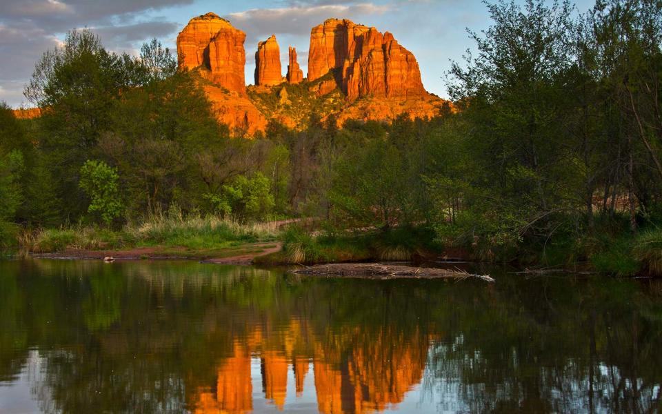 Watching the sun set can be a near-spiritual experience in the raw beauty of Sedona, where the desert meets the mountains. Sedona is known for its famous red rock buttes, and the suns setting rays make the vibrant colors of the landscape glow against the deepening blue of the desert sky. To maximize the experience, spend the day hiking up to Red Rock Crossing near the Crescent Moon Ranch and stick around for sunset along the creek. For an easier adventure, drive to Airport mesa to watch the sun disappear behind Bell Rock, Cathedral Rock, and Courthouse Butte.