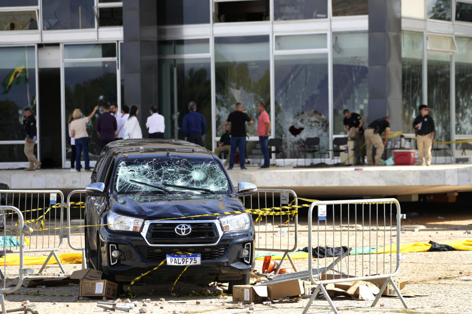 A government vehicle parked outside the Brazilian Supreme Court building, damaged by supporters of Brazil's former President Jair Bolsonaro, in Brasilia, Brazil, Tuesday, Jan. 10, 2023. Bolsonaro supporters who refuse to accept his election defeat stormed Congress, the Supreme Court and presidential palace Sunday, a week after the inauguration of his leftist rival, President Luiz Inacio Lula da Silva. (AP Photo/Eraldo Peres)