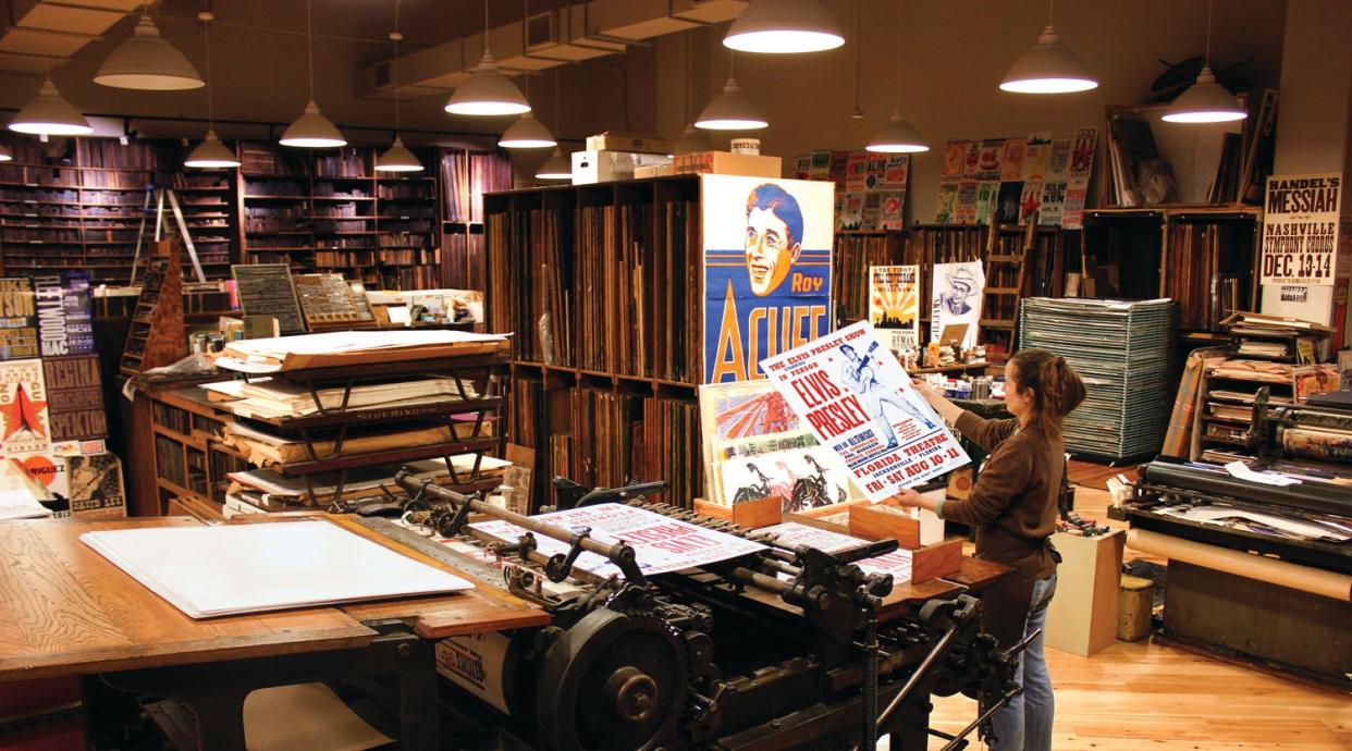 Celene Aubry, director at Hatch Show Print, checking out a reprint of a vintage Elvis Presley concert poster hot off the press.