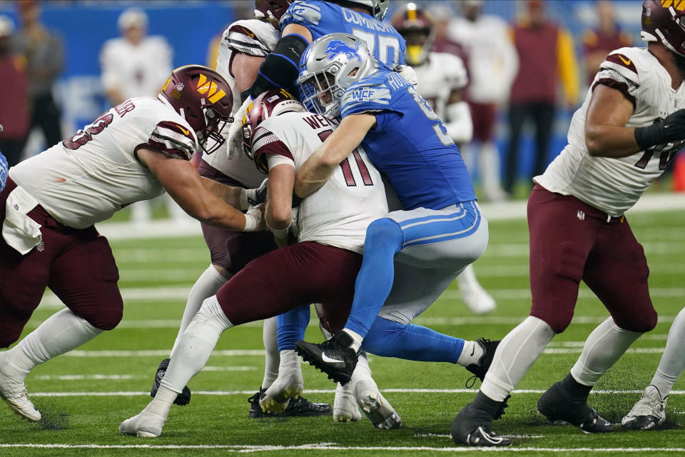 Washington Commanders quarterback Carson Wentz (11) is sacked by Detroit Lions defensive end Aidan Hutchinson (97) during the first half of an NFL football game Sunday, Sept. 18, 2022, in Detroit. (AP Photo/Paul Sancya)