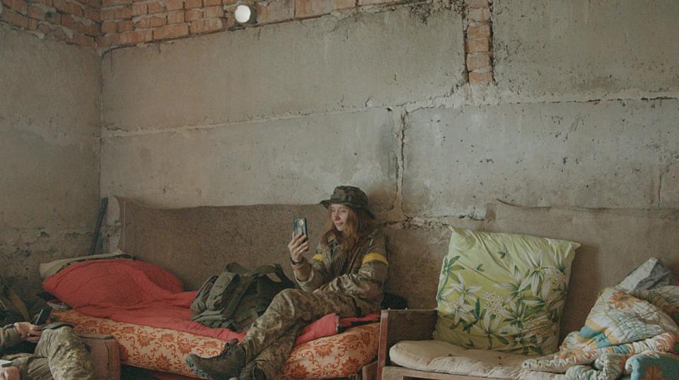 俄羅斯去年入侵烏克蘭全境，艾莉莎決定親赴烏東前線，扛起攝影機與槍。圖為她抓緊時間，與在基輔的兒子視訊通話。（艾莉莎提供）