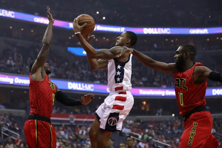 Bradley Beal of the Washington Wizards puts up a shot in front of Paul Millsap (L) and Tim Hardaway Jr. of the Atlanta Hawks in Game Five of the Eastern Conference quarter-finals during the 2017 NBA Playoffs, in Washington, DC, on April 26