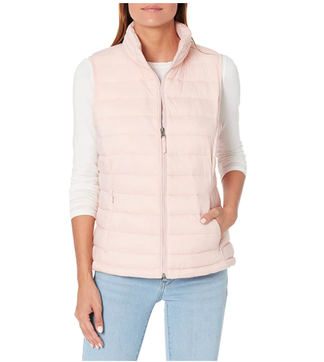 Model wears Amazon Essentials Womens Lightweight Water-Resistant Packable Puffer Vest in light pink with jeans. Image via Amazon.