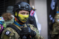 FILE - In this Jan. 18, 2021, file photo, a man wearing a Hawaiian pattern face mask attends a rally in Richmond, Va. People following the anti-government "boogaloo" movement, which promotes violence and a second U.S. civil war, have been showing up at protests across the nation armed and wearing tactical gear. But the movement has adopted an unlikely public and online symbol: Hawaiian print shirts. (AP Photo/John C. Clark, File)