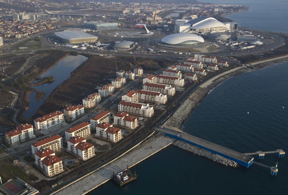 An aerial view from a helicopter shows the Olympic Park (top) under construction and the Olympic Village (bottom) in the Adler district of the Black Sea resort city of Sochi, December 23, 2013. Sochi will host the 2014 Winter Olympic Games in February. Picture taken December 23, 2013. REUTERS/Maxim Shemetov (RUSSIA - Tags: CITYSCAPE BUSINESS CONSTRUCTION SPORT OLYMPICS)