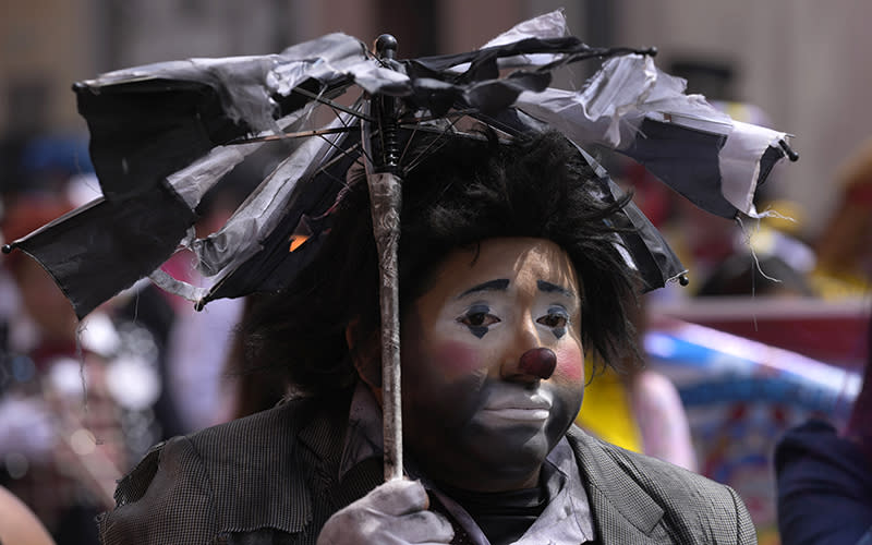 "Triston" the clown, dressed in festive black attire, marches celebrating Peruvian Clown Day