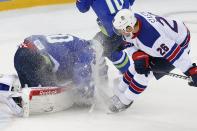 Slovenia goaltender Luka Gracnar dives on the puck in front of USA forward Paul Stastny during the 2014 Winter Olympics men's ice hockey game at Shayba Arena Sunday, Feb. 16, 2014, in Sochi, Russia. (AP Photo/Petr David Josek)