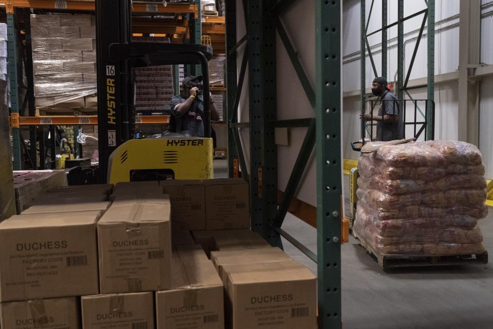 Workers load the warehouse with food items at The Capital Area Food Bank, Tuesday, Oct. 5, 2021, in Washington. (AP Photo/Jacquelyn Martin)