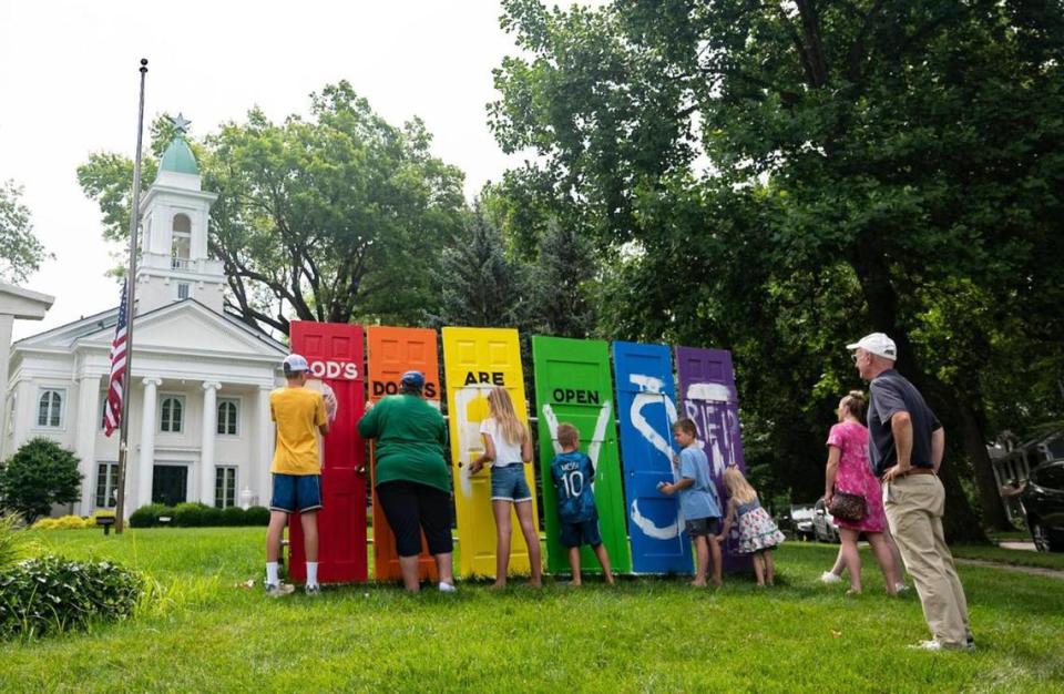 Church and community members sanded off an anti-LGBTQ message spray painted on doors on the lawn of Kansas City United Church of Christ, 205 W. 65th St., on Thursday, July 7, 2022. The group was preparing to repaint the symbolic doors after the damage was discovered outside the church.