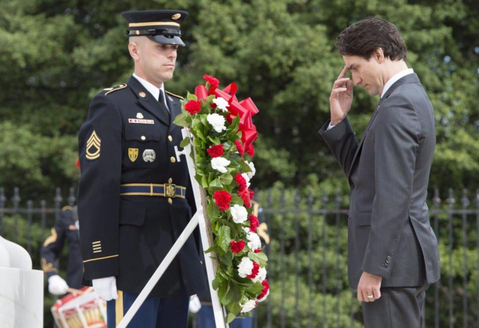 Prime Minister Justin Trudeau does the sign of the cross after laying a wreath at the Tomb of the Unknown Soldier at the Arlington Cemetery Friday, March 11, 2016 in Arlington, Virginia. THE CANADIAN PRESS/Paul Chiasson