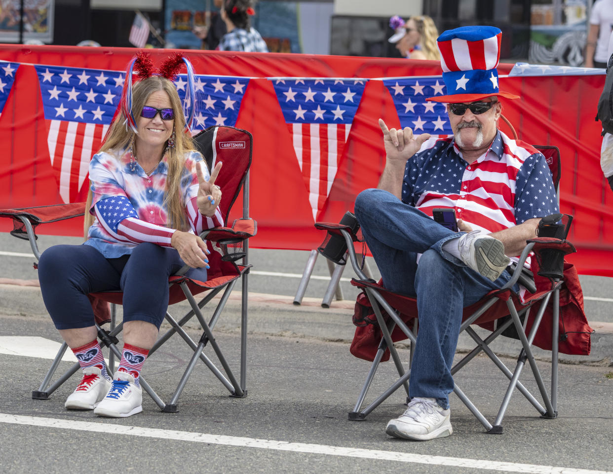 Huntington Beach, CA - July 04: Robin and Ray Prochnow of Costa Mesa sit along Pacific Coast Highway in Huntington Beach just prior to the start of the 119th Independence Day Parade on Tuesday, July 4, 2023. (Photo by Mark Rightmire/MediaNews Group/Orange County Register via Getty Images)