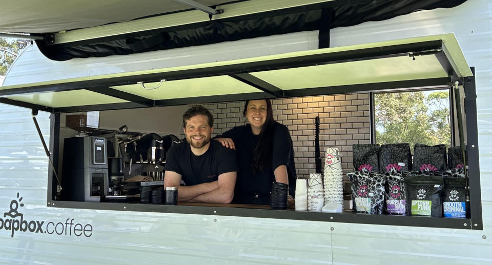 Sarah and Greg seen through the window of their coffee van. 