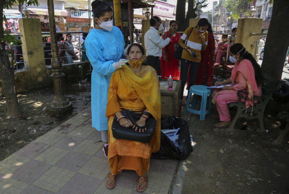 A health worker takes a nasal swab sample of a woman to test for COVID-19 in Jammu, India, Monday, Sept.13, 2021. (AP Photo/Channi Anand)