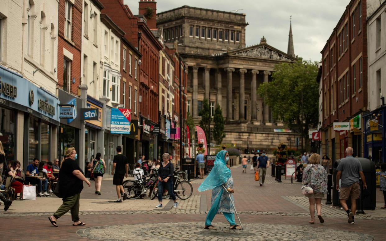  Original description: Members of the public walk through the centre of Preston, north west England on August 8, 2020, as local lockdown restrictions are reimposed due to a spike in cases of the novel coronavirus in the city. - - Oli Scarff/AFP
