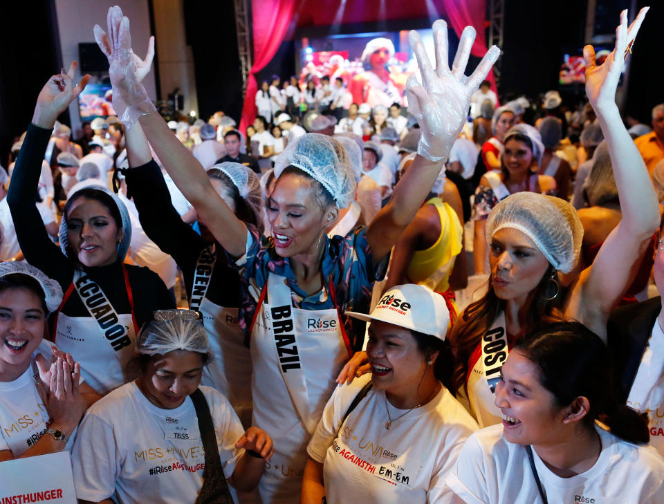 Miss Universe candidates participate in a food reliefs packing event in the Philippines